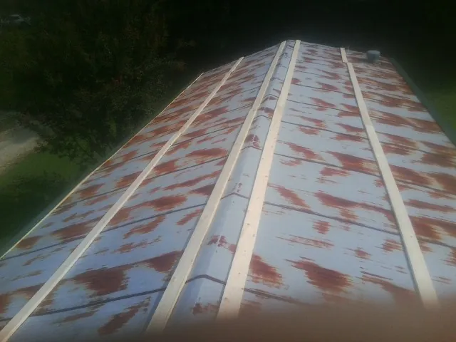 Rusted metal roof panels with new wood purlins before replacement — Storm Damage Roof Repair in Acushnet by Roofing Brothers