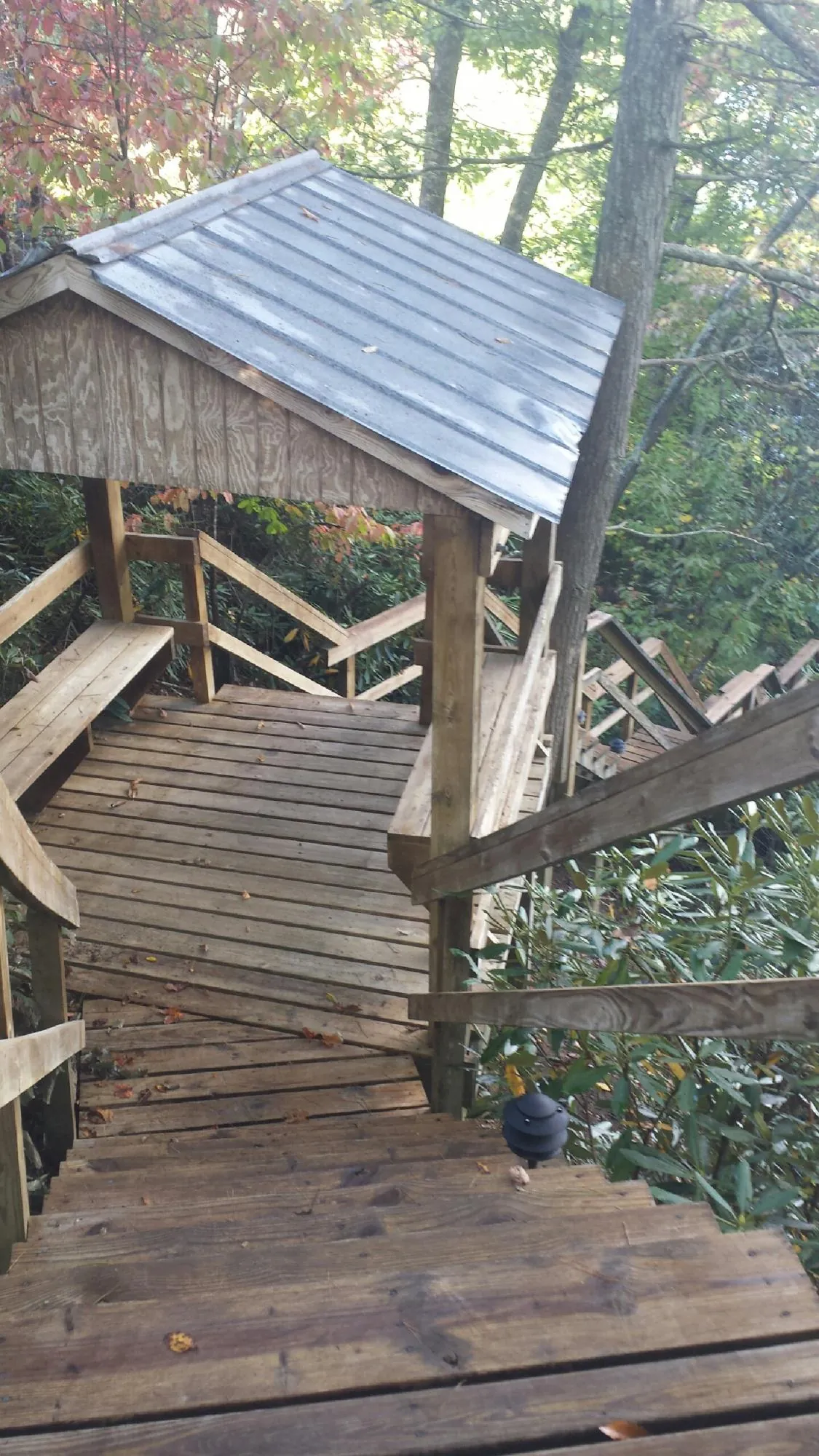 Metal roofed shelter over wooden steps on a wooded walkway — Skylight Repair & Installation work by our crew in Acushnet