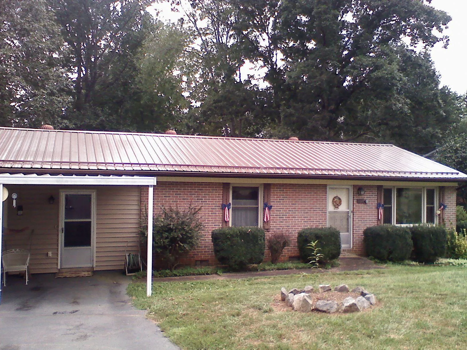 Bronze metal roof and carport on a brick ranch home — Roof Repair work by our crew in Acushnet